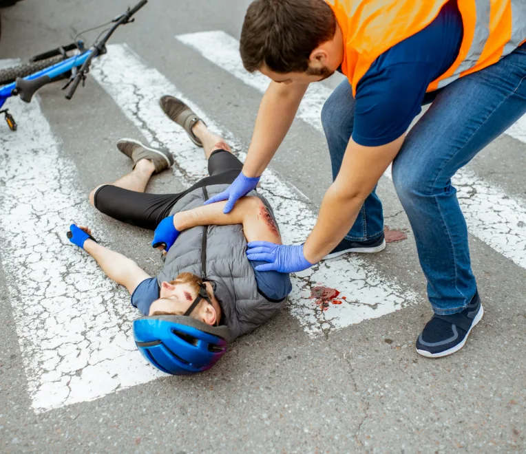 First responder helping an injured person in a crosswalk